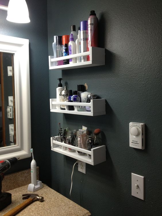 White shelves on a dark wall in the bathroom.