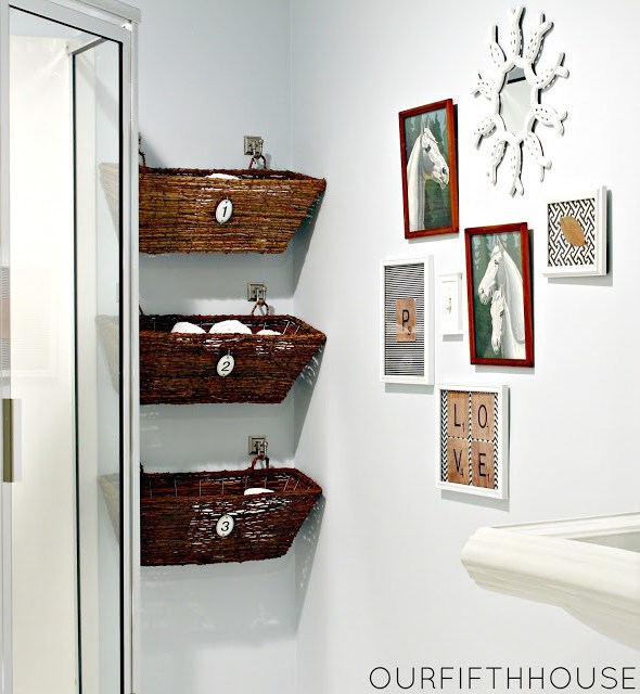 Three wicker window boxes hung in the bathroom used for storage.