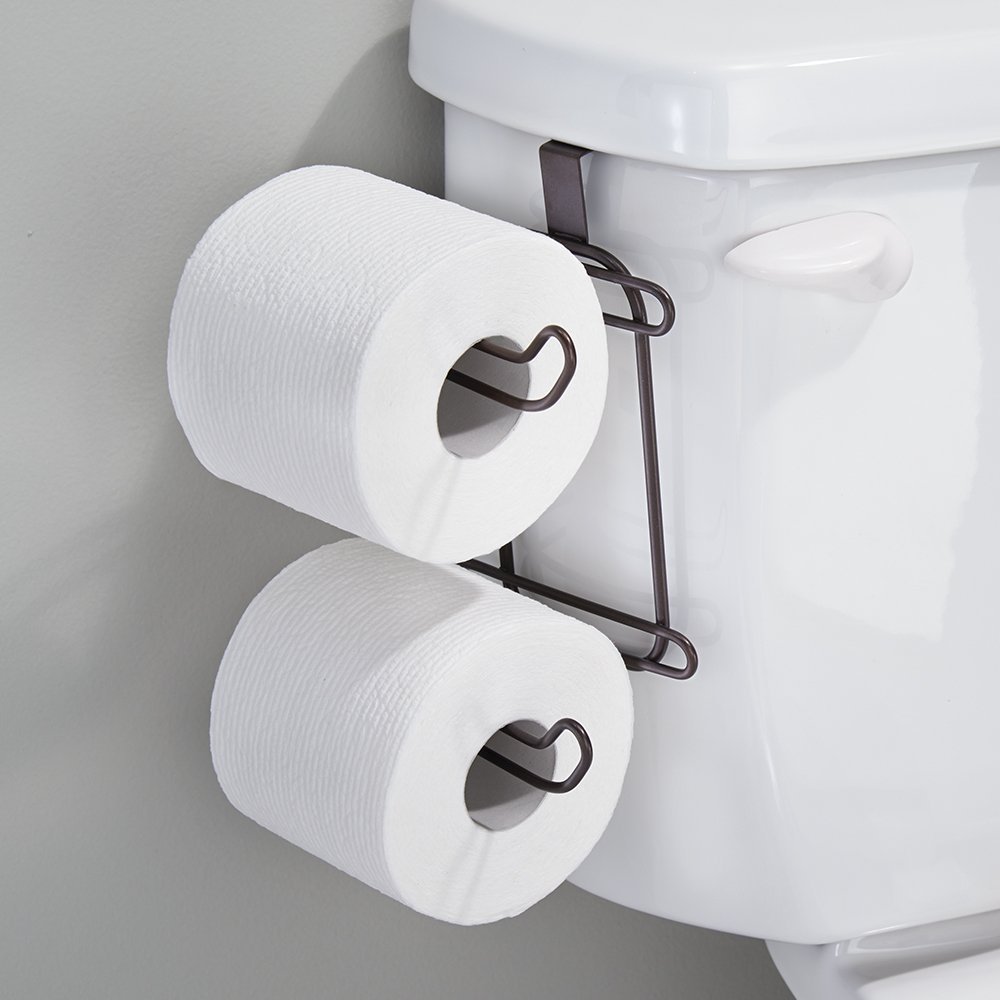 A metal toilet paper holder hanging on the side of the toilet.