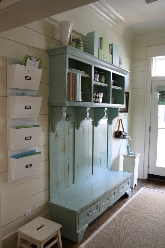 A distressed blue/green wooden bench and coat rack.