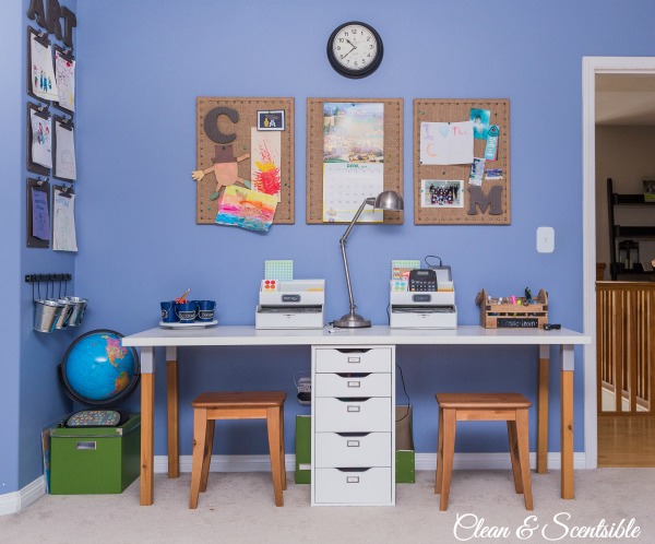 A room painted indigo with a small desk and stools.