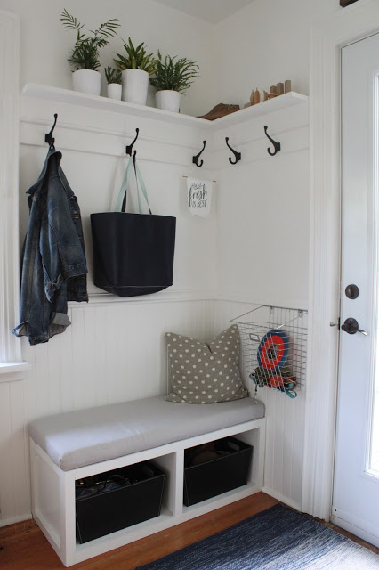 A corner bench and hooks on the wall for coats and bags.