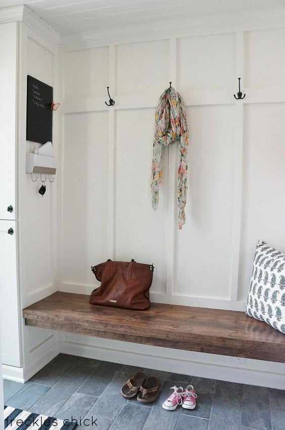 A wooden bench unit built into a nook in the entryway.