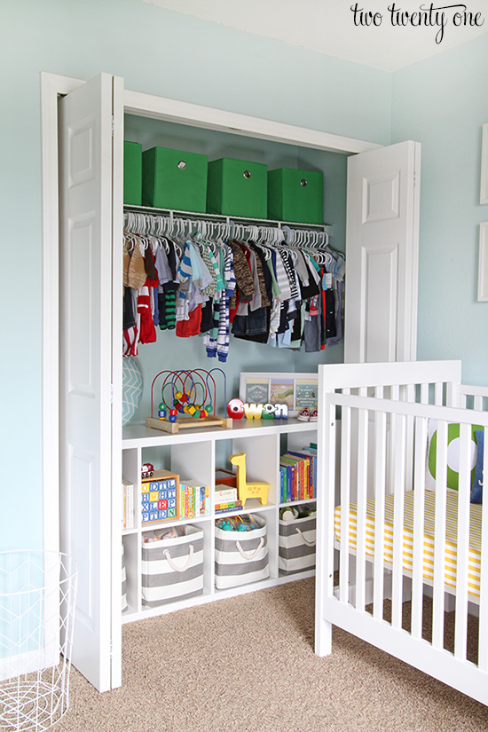 A nursery with toys and clothes on a shelf in the closet.