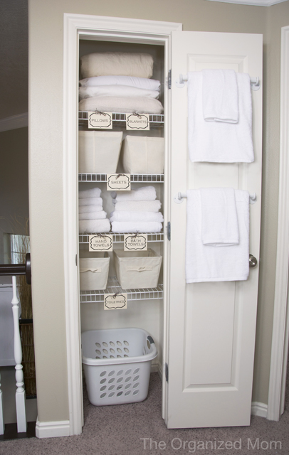 An all white closet with the door ajar.