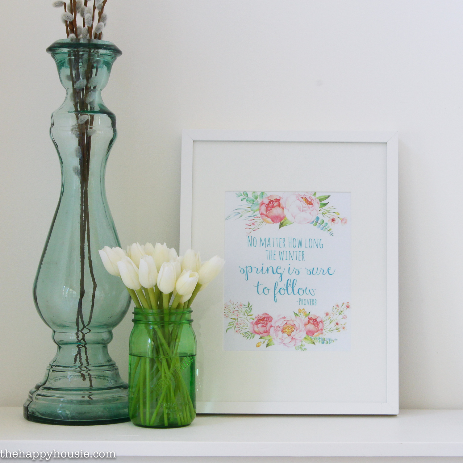 Tulips are in a green glass with a tall vase beside it and a printable.