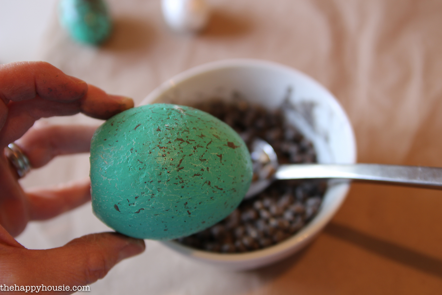 Using the popcorn seeds to spackle the Easter egg.