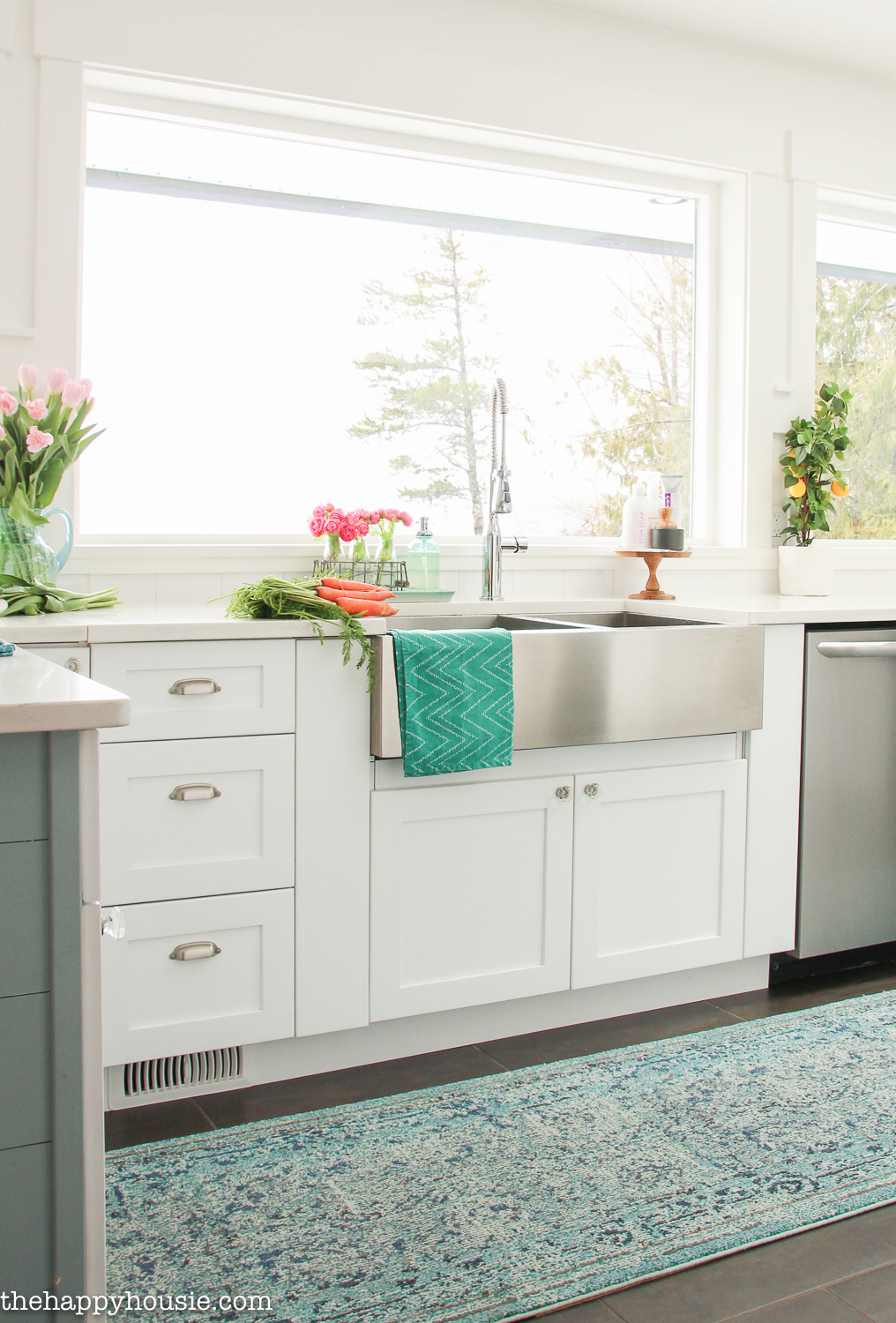 A turquoise cloth hangs from the apron sink in the kitchen.