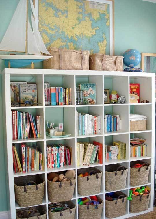 A shelf with books and baskets in the cubby holes.