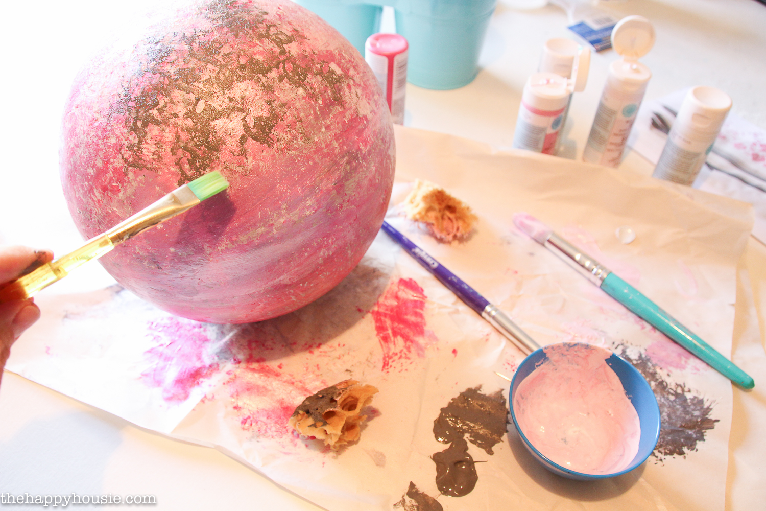 The sphere, paint and brushes on the table.