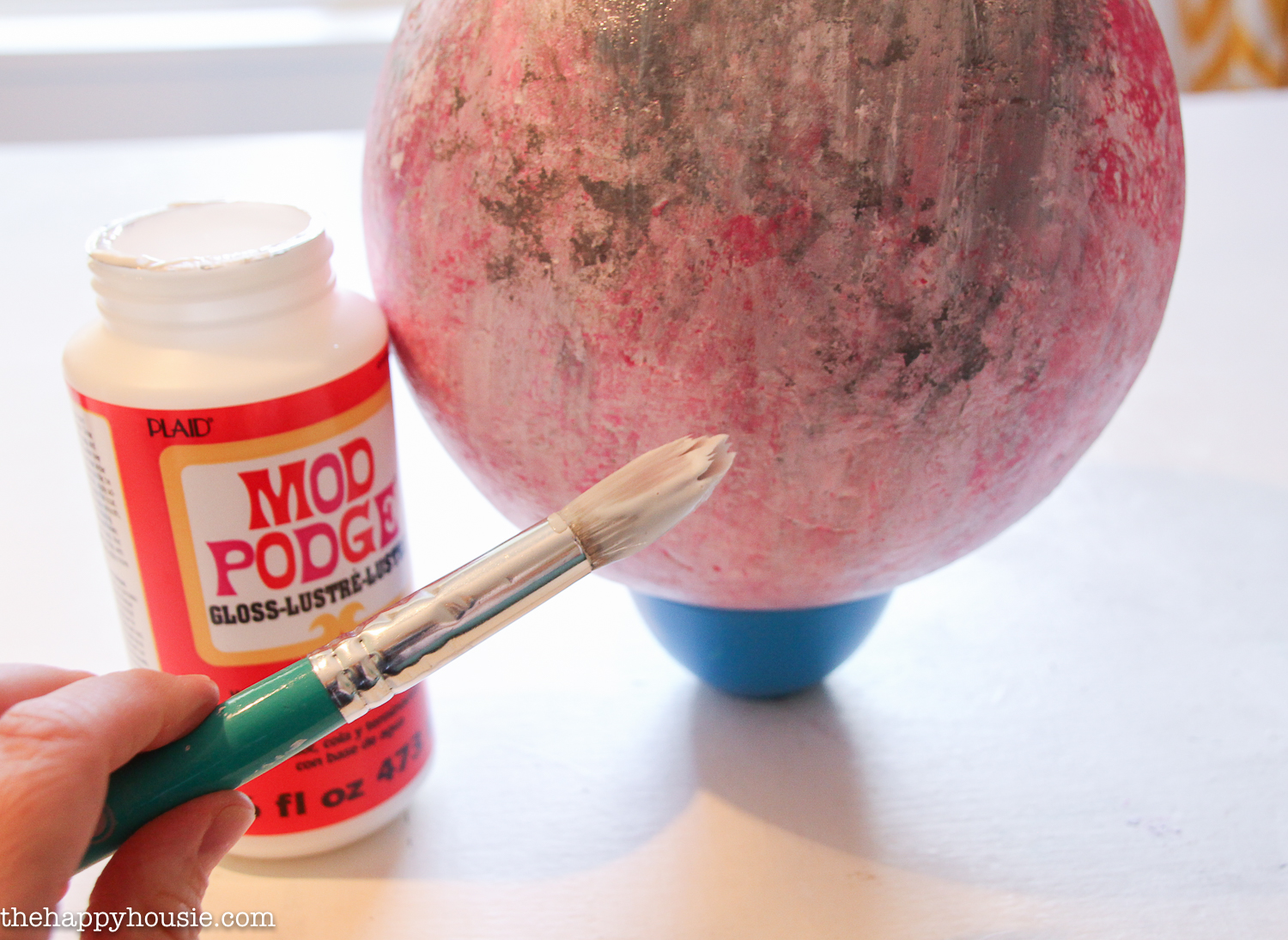 Using mod podge in gloss on the sphere.