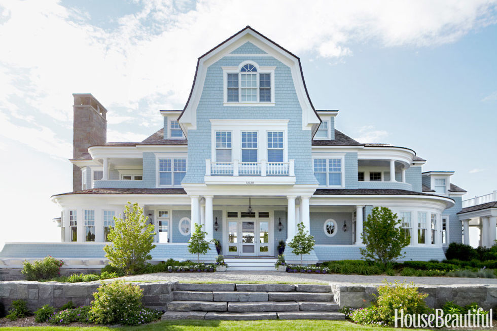 A very large light blue house with stone steps.