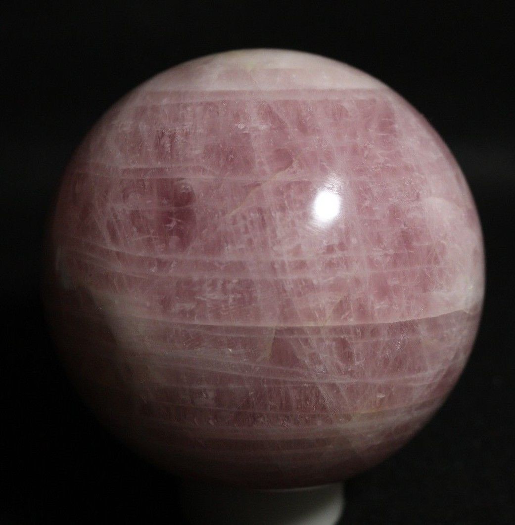 A real rose quartz sphere on a stand.