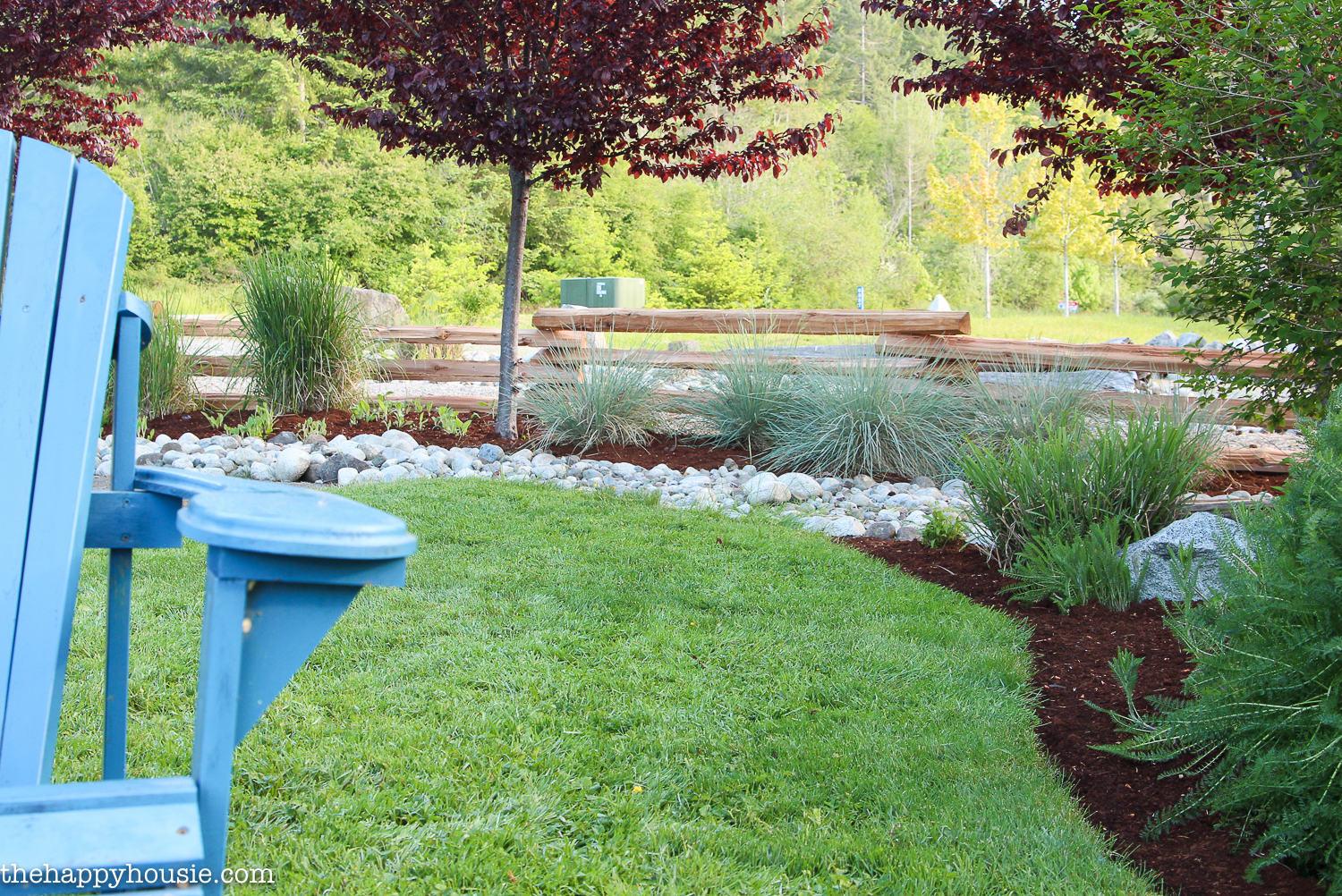 A front yard landscaped with river rock and garden beds.
