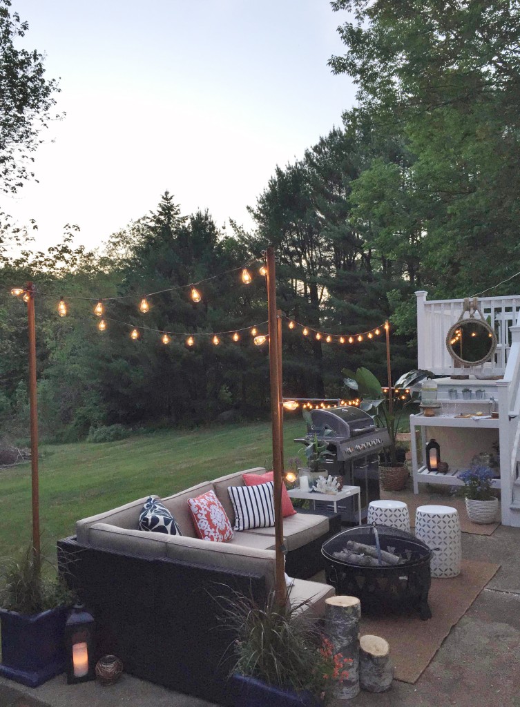 A small outdoor corner couch, a bbq and lights.