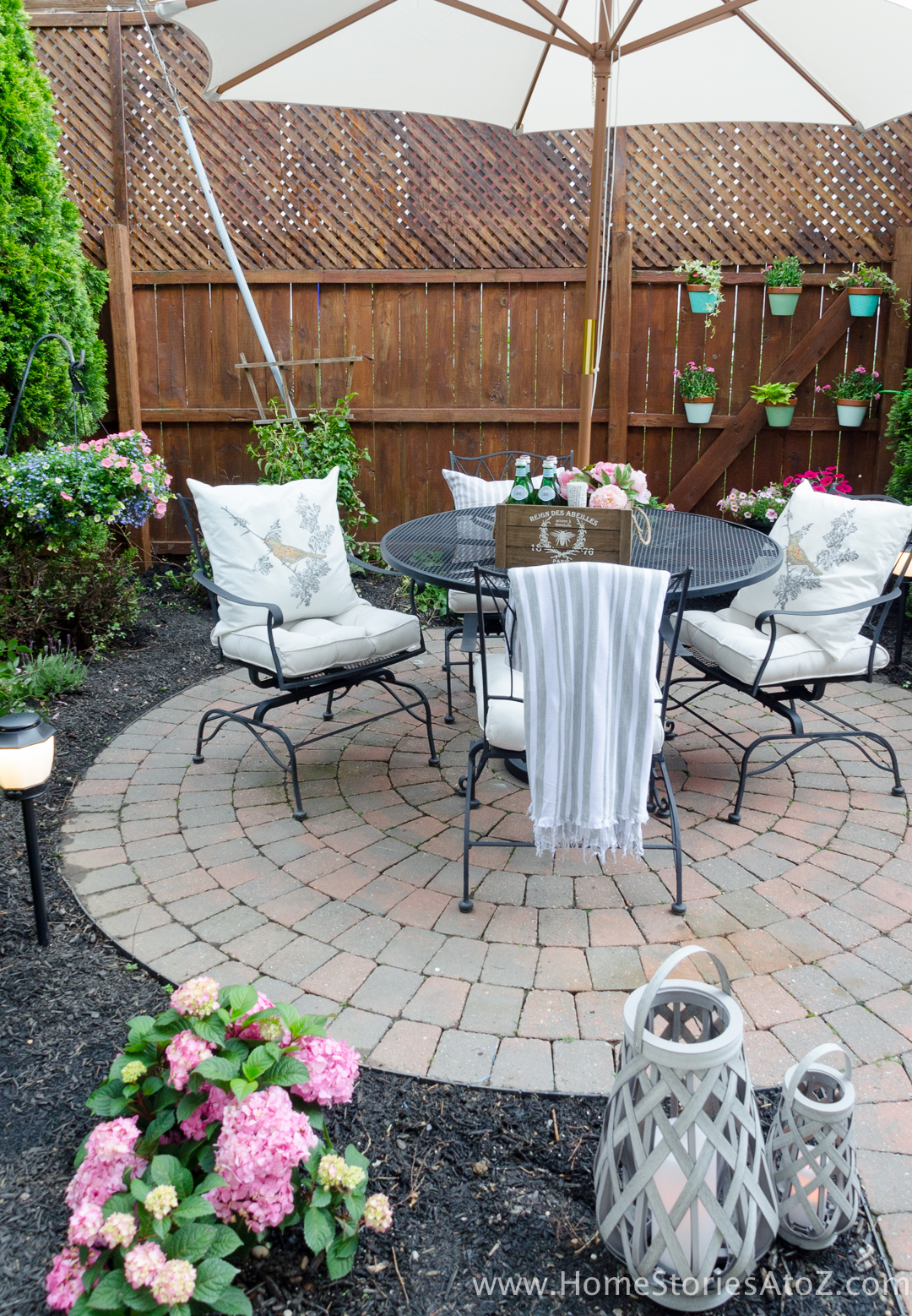 A round brick patio with a round table.