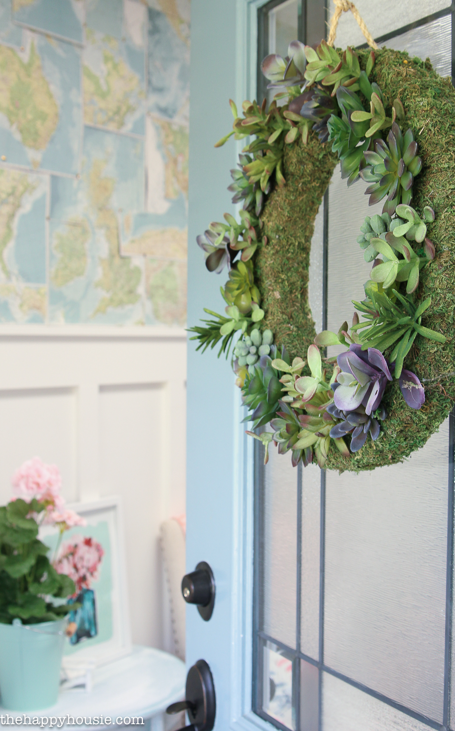 A green wreath with succulents is on the front door.