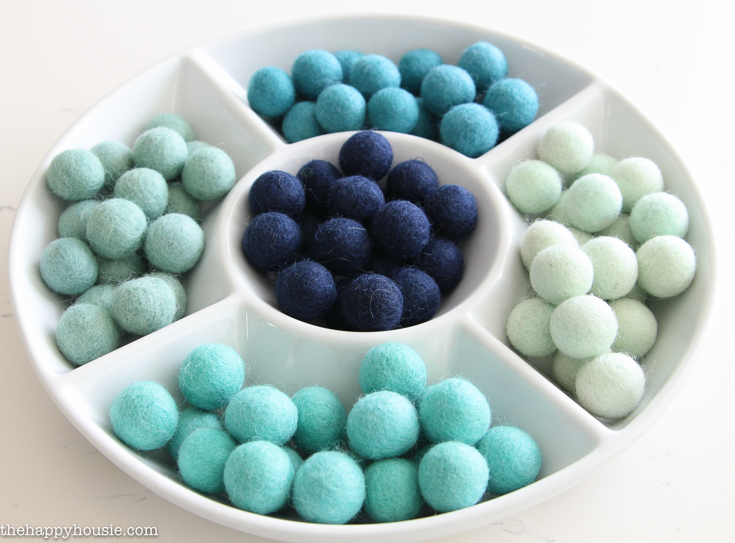 The felt balls separated into the various shades of colours by using a vegetable tray.