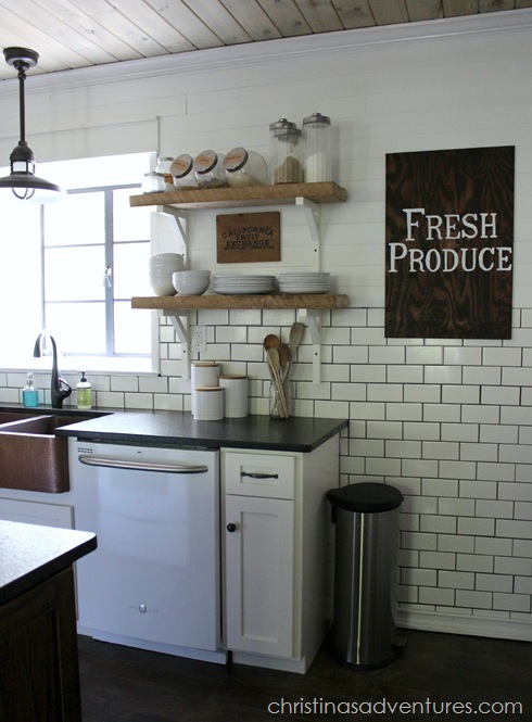 Wooden shelves and white brackets in a white kitchen.