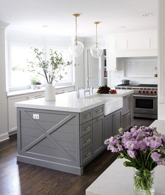 A slate grey kitchen island with flowers on top.
