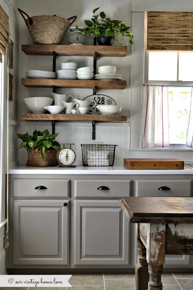 Light grey cabinets with black pulls, plus open shelving in kitchen.