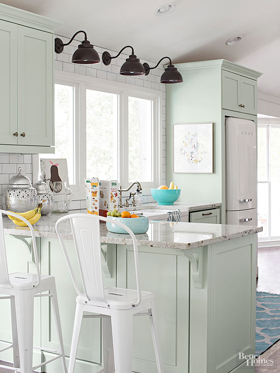 Pale mint kitchen cabinets with black light and white bar chairs.