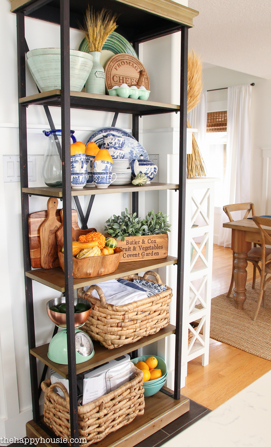 Open shelving in the dining room with vases, plates and baskets.