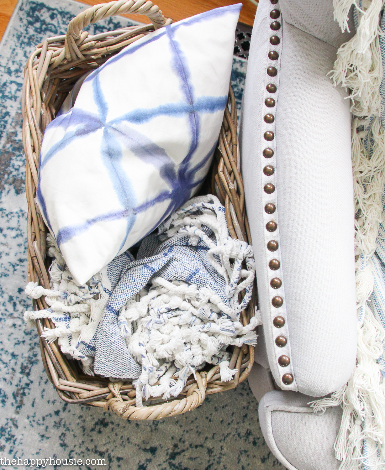 Small basket filled with a pillow and throw blanket.