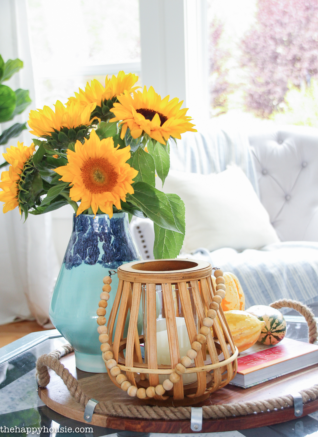 A light and dark blue vase holds the sunflowers on the coffee table.