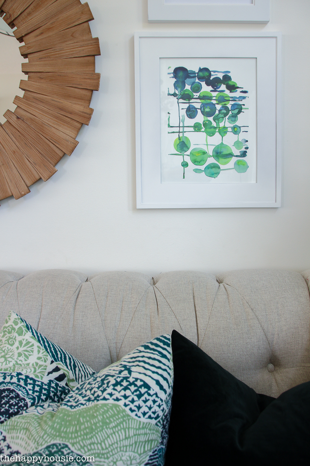 Graphic green and blue watercolour is above the couch.