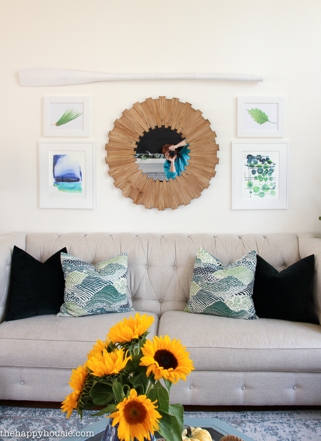 A round wooden mirror above the couch on the wall.