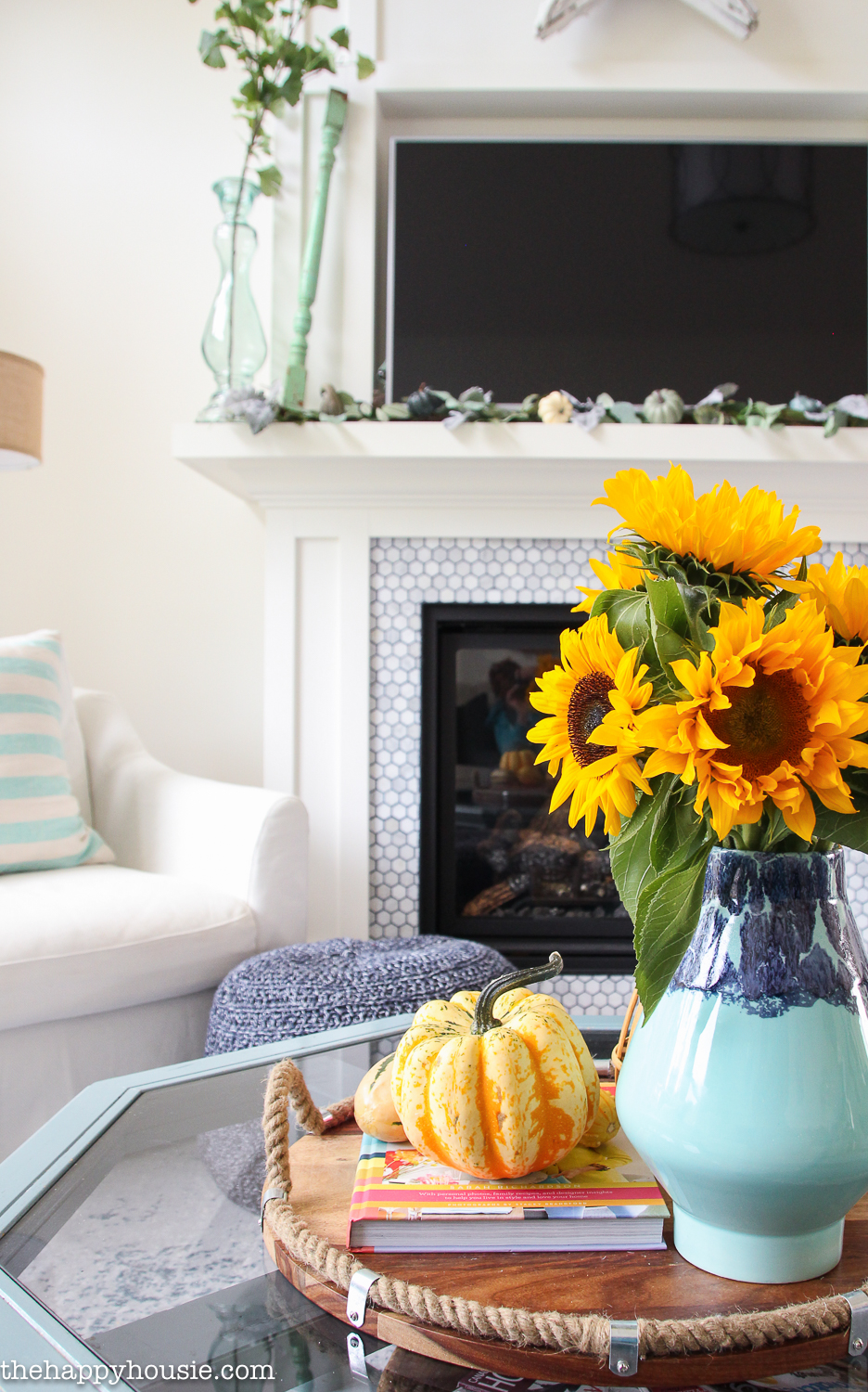 Bright sunflowers in a vase that is blue on the coffee table.