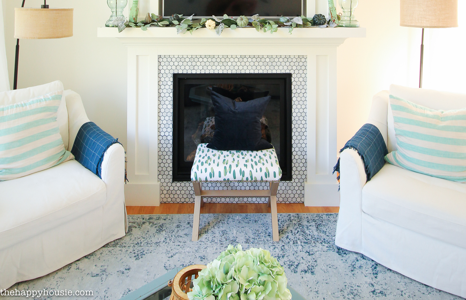 Two large white Ikea Farlov chairs flanking the fireplace.