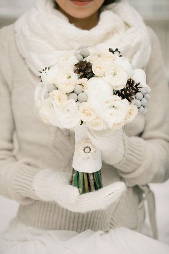 An all white bouquet with pinecones.