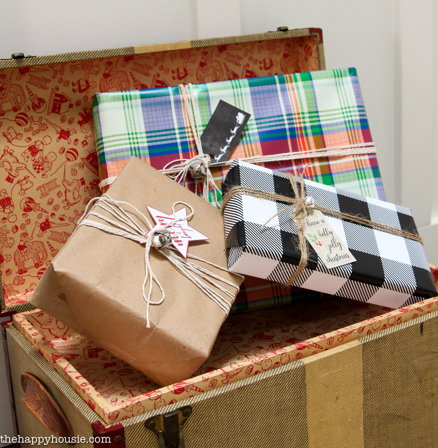 A vintage trunk is filled with wrapped presents.