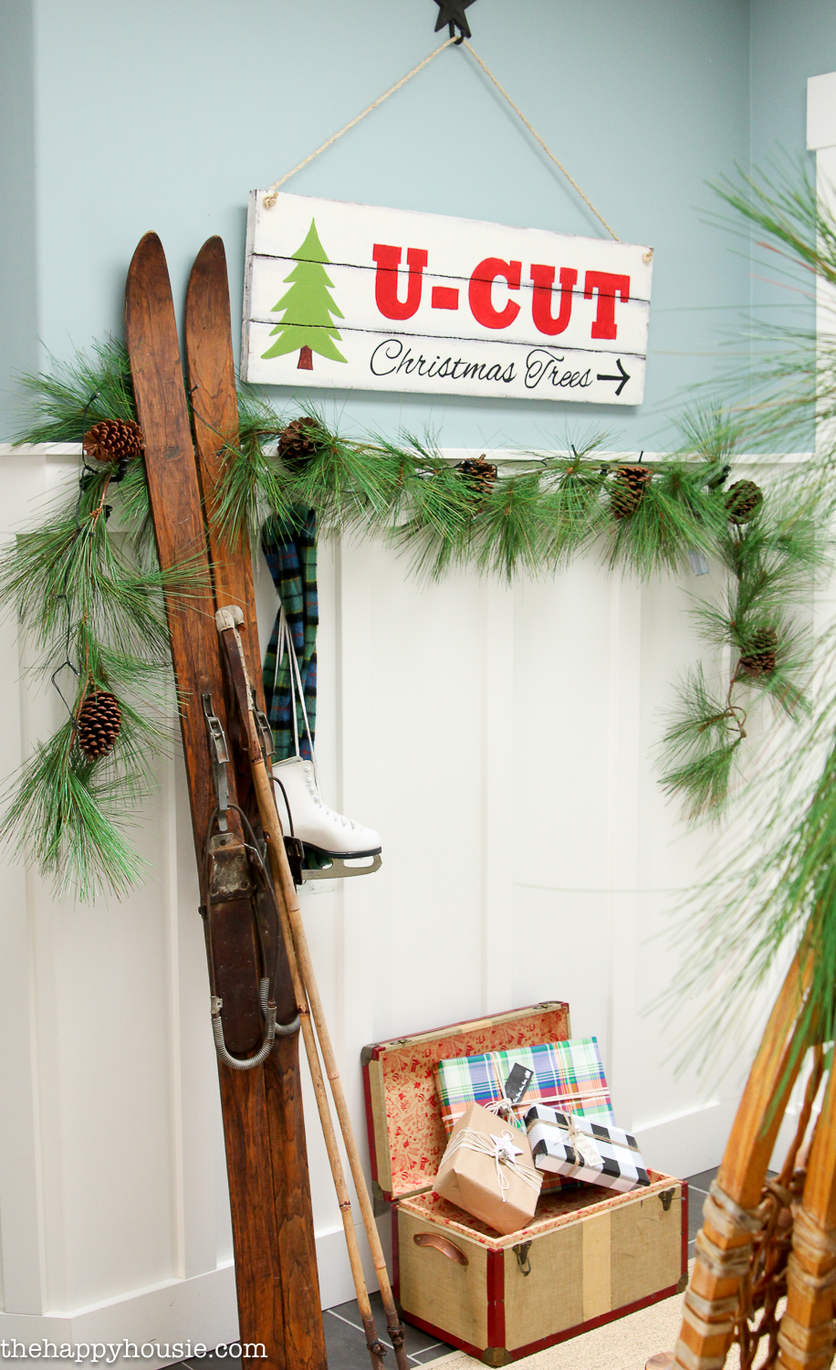 Vintage skis are leaning against the wall beside a sign that say U-Cut.