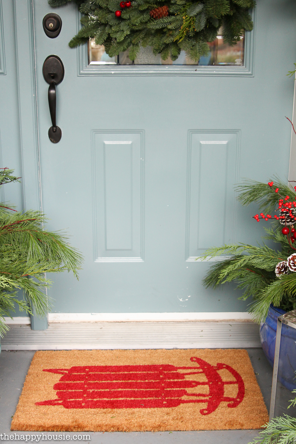 A light blue door with a wreath on it.