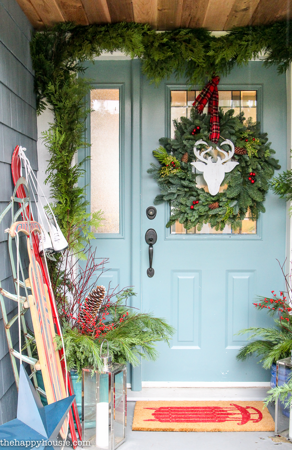 The front door with a green wreath and a deer and antler image.