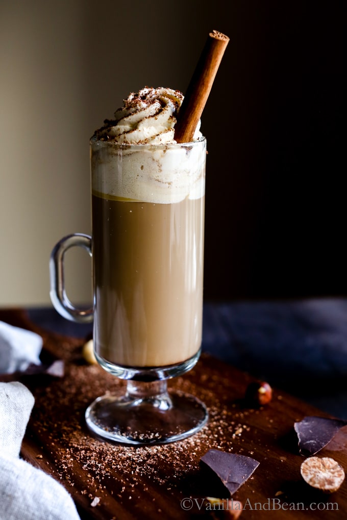 A vanilla and bean coffee drink with a stick of cinnamon.
