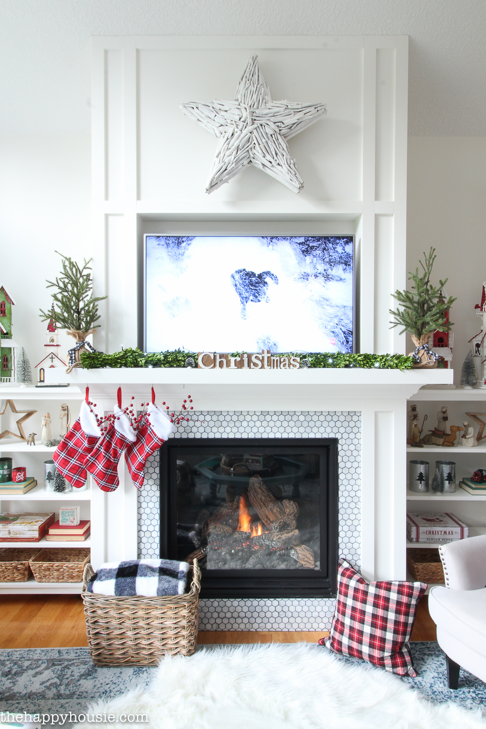 A white fireplace mantel with a white fur rug in front of it.