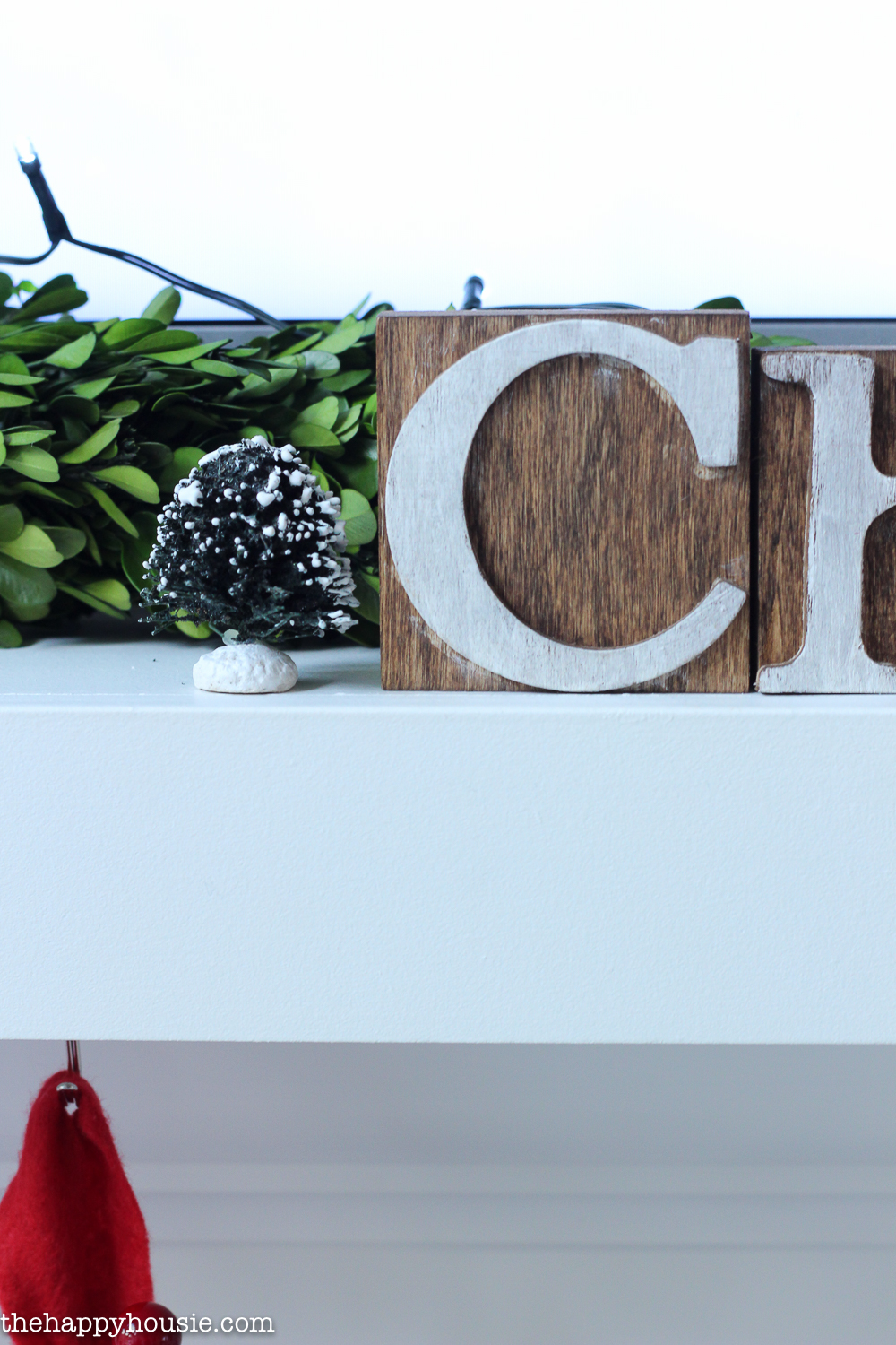 A wooden Christmas sign is on the mantel.
