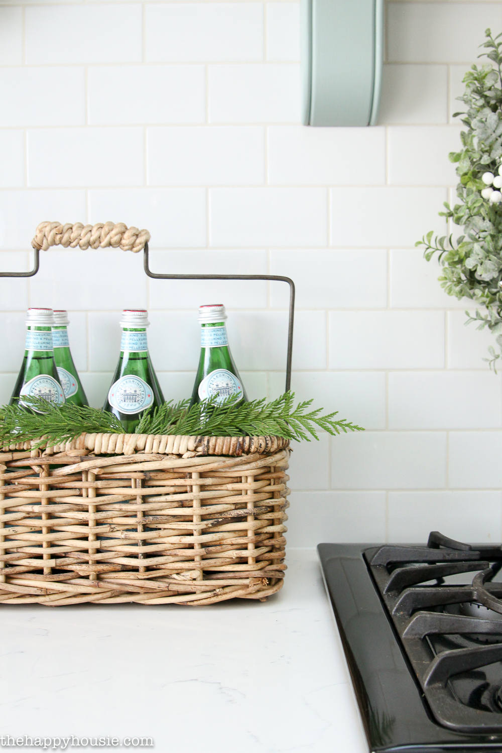 A wicker basket with a handle holds Perrier water.