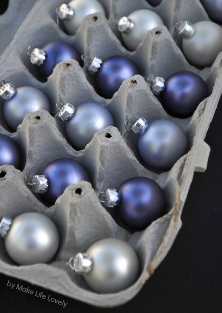 Blue and silver balls in an egg container.