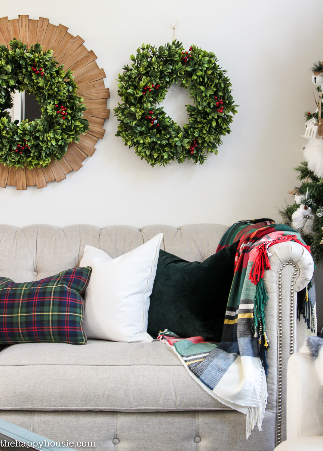 Wreaths are hanging above the couch.