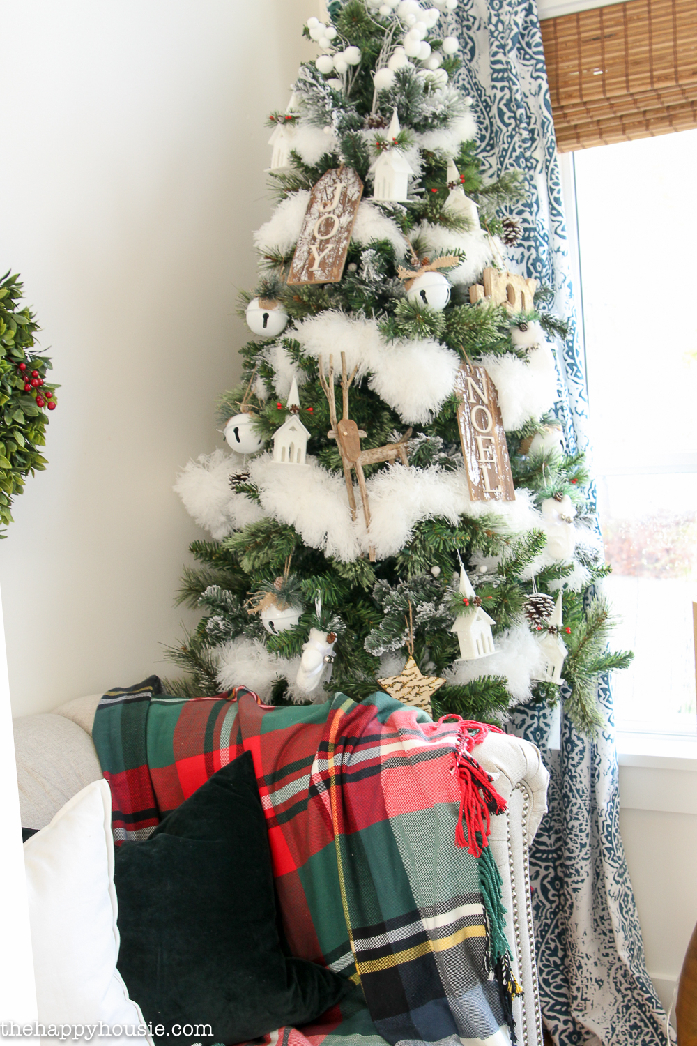 A decorated Christmas tree is in the corner of the room.