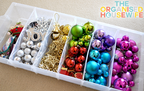 A plastic container with sections and the ornaments organized inside it.