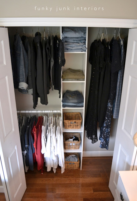 A small closet with a shelf down the middle and baskets filled with items.