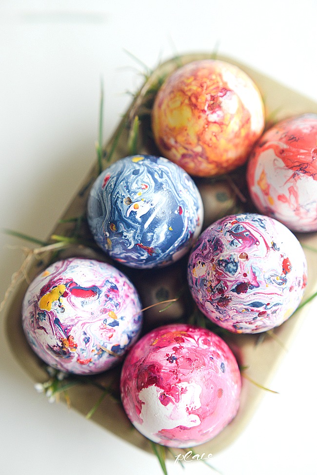 A carton of marbled eggs in bright colours.