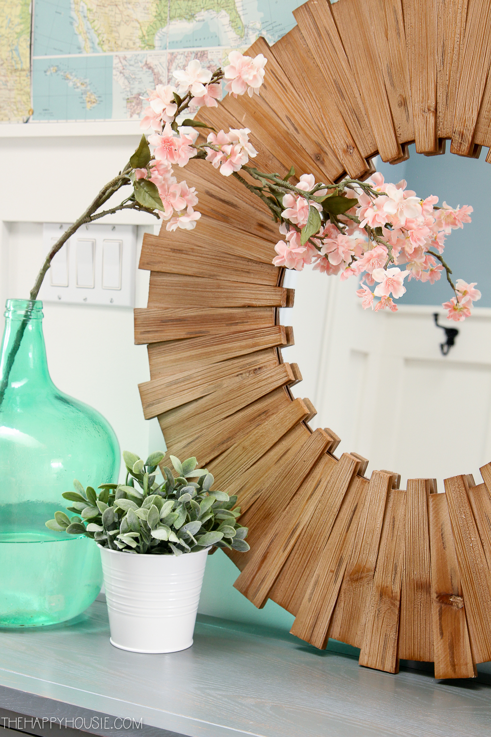 Small pink flowers and a wooden mirror.