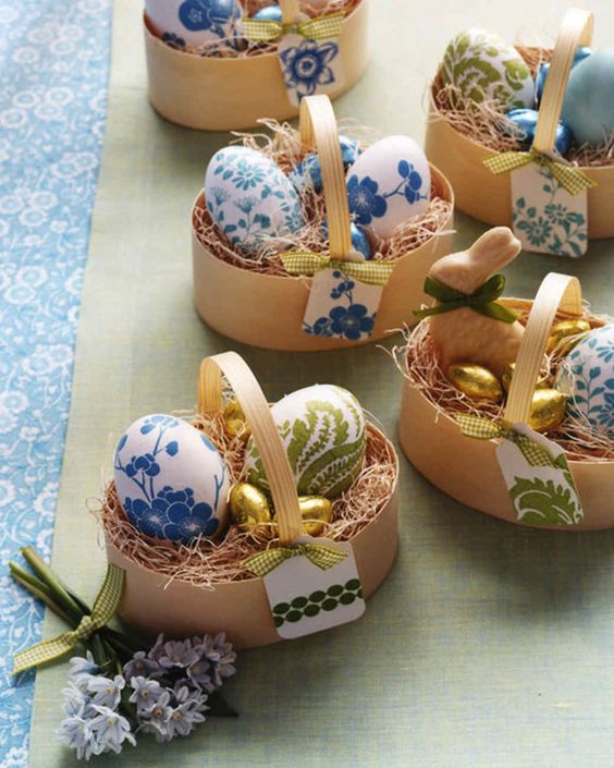 Little baskets full of eggs with chocolates beside them.